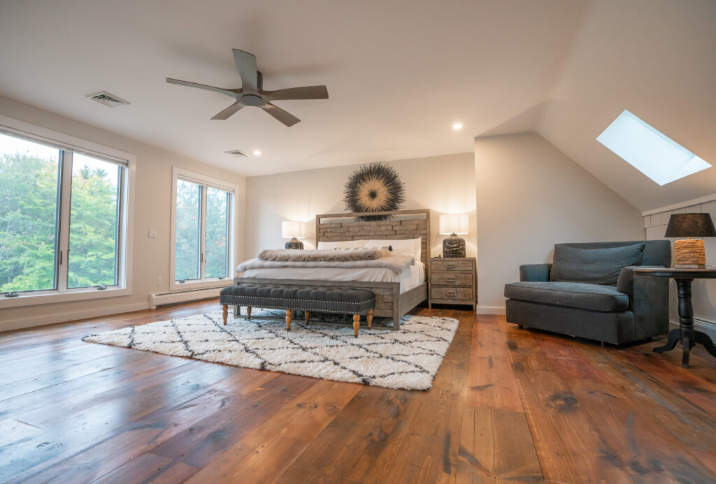 Master bedroom with en suite bathroom and views of the mountain, yard, and pond